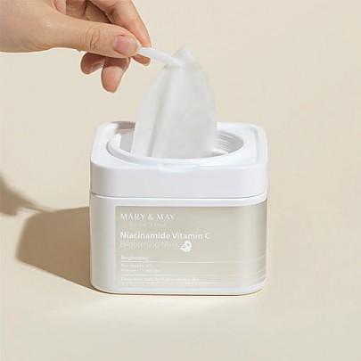 Sheet mask being removed from sachet with tweezers