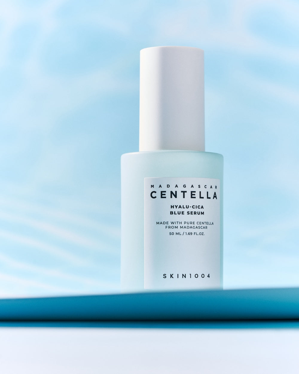 Blue serum bottle photographed against water background
