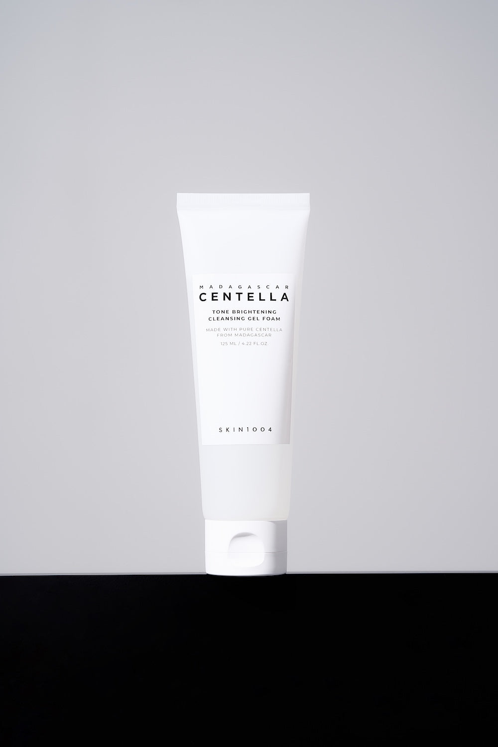 Cleanser tube next to toner bottle for routine flatlay