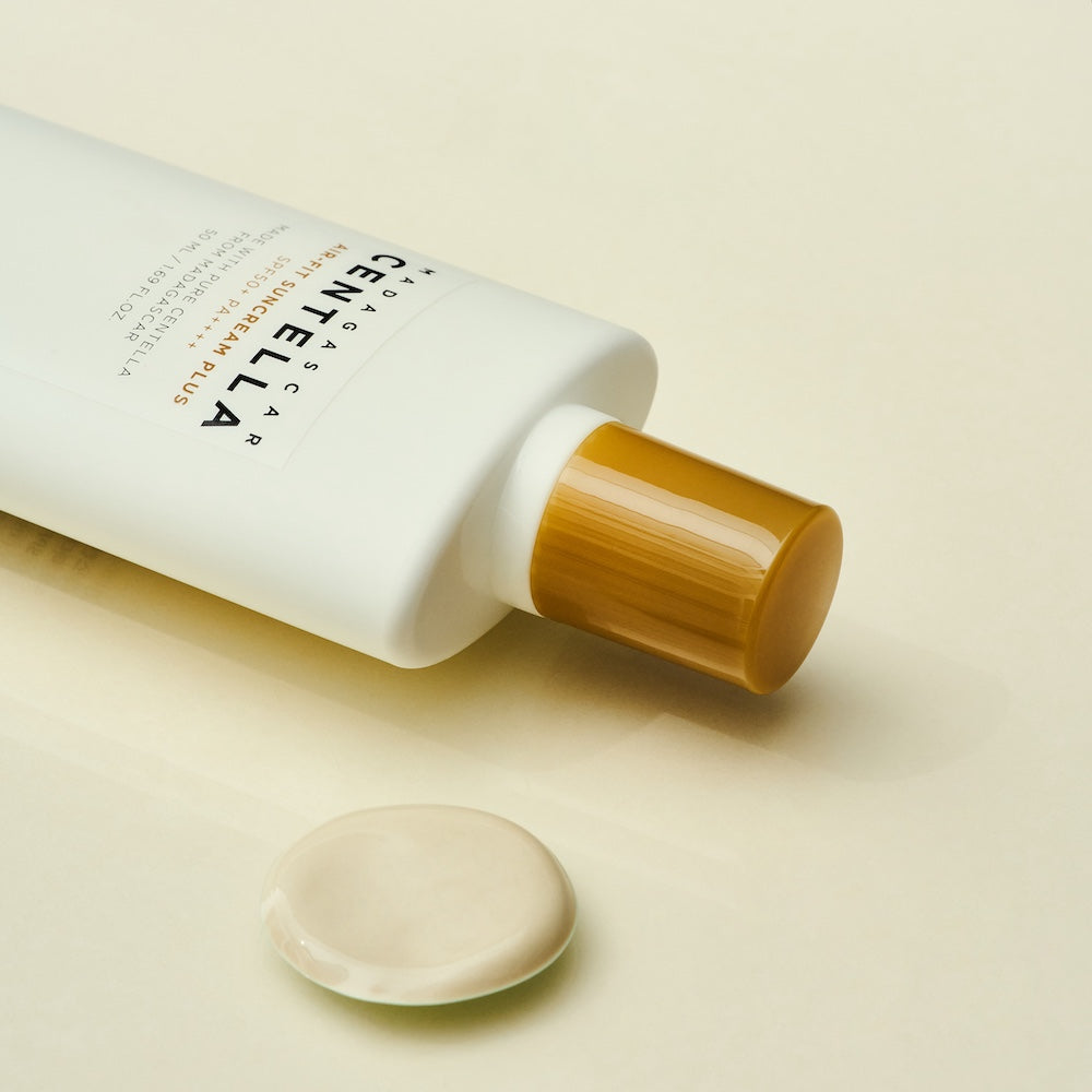 Suncream bottle held between two fingers